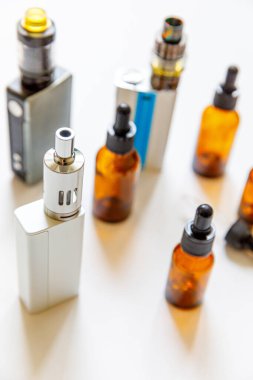 Vaping cihazı elektronik sigara ve beyaz arka planda izole edilmiş sıvı şişeler. Alternatif sigara içmek için bir cihaz. Vaping dükkanı konsepti. Vaper için Gadget. Buhar aksesuarları