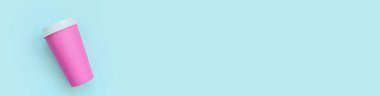 Düz dizayn edilmiş pembe kağıt kahve fincanı mavi pastel renkli arka planda. Paket içecek konteynırı. Günaydın uyanık kavramı. İçkinin şablonu. Üst görünüm kopyalama alanı afişi