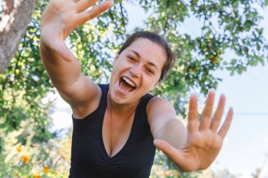 Dışarıda gülümseyen genç bir kadın. Güzel esmer kız parkta dinleniyor ya da bahçe yeşili arka planda. Yazın özgür ve mutlu bir kadın. Özgürlük mutluluğu tasasız mutlu insanlar konsepti
