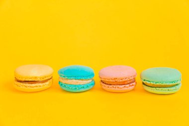 Tatlı badem renkli tek boynuzlu at pembe, mavi, yeşil badem kurabiyesi ya da modern moda arka planında izole edilmiş kurabiyeli pasta. Fransız kurabiyesi. Asgari gıda fırını konsepti. Boşluğu kopyala