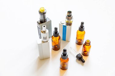 Vaping cihazı elektronik sigara ve beyaz arka planda izole edilmiş sıvı şişeler. Alternatif sigara içmek için bir cihaz. Vaping dükkanı konsepti. Vaper için Gadget. Buhar aksesuarları