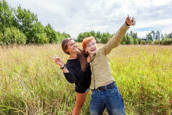 Summer holidays vacation happy people concept. Loving couple having fun together in nature outdoors. Happy young man taking making romantic selfie with girlfriend. Happy loving couple at summertime