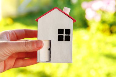 Kadın içinde minyatür model ev yeşil arka planda. Eco Village, soyut çevre geçmişi. Gayrimenkul ipoteği sigortası rüya ev ekolojisi kavramı