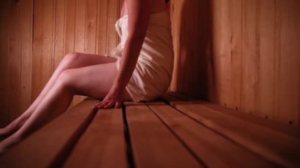 伝統的なロシアの古い浴場Spaの概念 伝統的なフィンランド式サウナのインテリアスチームルームでリラックスタオルで女性 田舎の村のバスコンセプトをリラックス — ストック動画