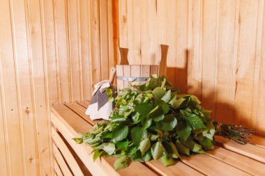 Geleneksel eski Rus hamamı SPA konsepti. İçişleri, geleneksel sauna aksesuarları ve huş ağacı süpürgesi kepçesiyle Finlandiya sauna saunası saunasının ayrıntılarını veriyor. Rahatlayın köy banyosu konsepti