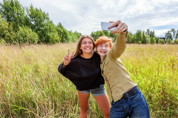 Summer holidays vacation happy people concept. Loving couple having fun together in nature outdoors. Happy young man taking making romantic selfie with girlfriend. Happy loving couple at summertime