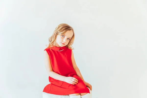 Dulce Niña Vestido Rojo Sentado Silla Contra Pared Blanca Casa — Foto de Stock