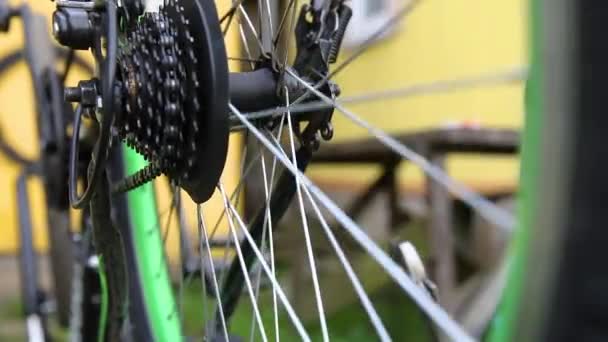 Mecánico de bicicletas reparaciones hombre bicicleta en taller de reparación de bicicletas, al aire libre. Mano de ciclista ciclista examina, fija el sistema de transmisión de ciclo moderno. Mantenimiento de bicicletas, concepto de tienda de deporte. — Vídeo de stock