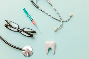 Sağlık diş sağlığı konsepti. İlaç ekipmanları steteskop beyaz sağlıklı diş gözlükleri mavi arka planda izole edilmiş. Dişçi doktor için cihaz. Diş sağlığı diş hekimi günü.