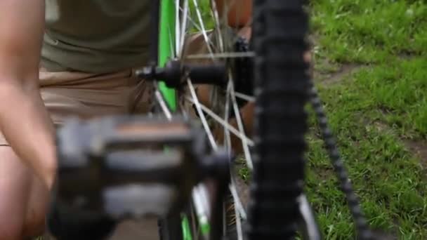 Fietsenmaker repareert fiets in fietsenmaker, buiten. Hand van fietser fietser onderzoekt, repareert moderne fiets transmissiesysteem. Fietsonderhoud, sport winkel concept. — Stockvideo
