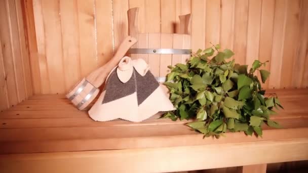 Tradiční stará ruská lázeňská koncepce lázní. Detail interiéru Finská sauna parní lázeň s tradičním saunovým příslušenstvím povodí březové koště naběračky. Relax country vesnice lázně koncept. — Stock video