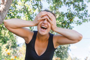 Dışarıda gülümseyen genç bir kadın. Güzel esmer kız parkta dinleniyor ya da bahçe yeşili arka planda. Yazın özgür ve mutlu bir kadın. Özgürlük mutluluğu tasasız mutlu insanlar konsepti