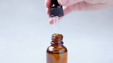Gerekli yağ pipetten şişeye dökülüyor. Esans sıvı kozmetik. Sıvı kozmetik serumlu damlatan cam şişe. Şurup, parfüm, aromaterapi konsepti. Güzellik Tedavisi