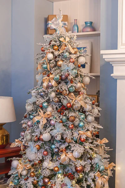 Klasik Noel yılbaşı ağacı gümüş ve beyaz süsleme oyuncakları ve balo ile süslenmiş. Modern klasik stil iç tasarım dairesi. Evde Noel arifesi
