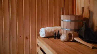 Geleneksel eski Rus hamamı SPA konsepti. Finlandiya sauna saunasında geleneksel sauna aksesuarları ve havlunun aromalı yağ kepçesi kullanılmış. Rahatlayın köy banyosu konsepti.