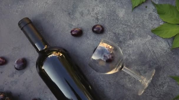 Top kilátás palack vörösbor, zöld szőlő, borosüveg és érett szőlő évjárat sötét kő asztal háttér. Borbolt borozó borászat vagy borkóstoló koncepció.