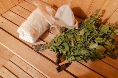 Geleneksel eski Rus hamamı SPA konsepti. İçişleri, geleneksel sauna aksesuarlarıyla Finlandiya sauna sauna saunası havlu süpürge kepçesi kepçesiyle dolu. Rahatlayın köy banyosu konsepti