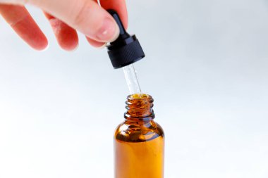 Gerekli yağ pipetten şişeye dökülüyor. Esans sıvı kozmetik. Sıvı kozmetik serumlu damlatan cam şişe. Şurup parfümü aromaterapi konsepti. Güzellik Tedavisi