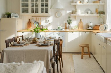 İskandinav klasiği beyaz ve ahşap çiçekli minimalist mutfak. Modern beyaz mutfak, çağdaş tarz iç tasarım. Boş parlak beyaz iç mekan, mutfak minimumu