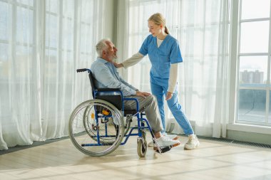 Emeklilik sağlık hizmetlerine destek ol. Hemşire tekerlekli sandalyedeki yaşlı adama yardım ediyor. Hasta ve kadın tıbbi bakım için huzurevinde. Engelli insanlar için tekerlekli sandalyede felçli bir adama bakan hemşire.