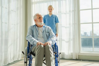 Emeklilik sağlık hizmetlerine destek ol. Hemşire tekerlekli sandalyedeki yaşlı adama yardım ediyor. Hasta ve kadın tıbbi bakım için huzurevinde. Engelli insanlar için tekerlekli sandalyede felçli bir adama bakan hemşire.