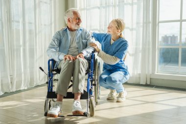 Emeklilik sağlık hizmetlerine destek ol. Hemşire tekerlekli sandalyedeki yaşlı adama yardım ediyor. Hasta ve kadın tıbbi bakım için huzurevinde. Engelli insanlar için tekerlekli sandalyede felçli bir adama bakan hemşire.