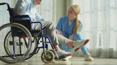 Emeklilik sağlık hizmetlerine destek ol. Hemşire tekerlekli sandalyedeki yaşlı adama yardım ediyor. Hasta ve kadın tıbbi bakım için huzurevinde. Engelli insanlar için tekerlekli sandalyede felçli bir adama bakan hemşire.