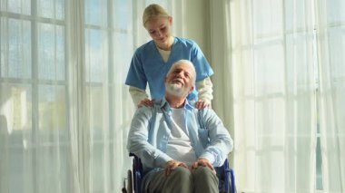 Emeklilik sağlık hizmetlerine destek ol. Hemşire tekerlekli sandalyedeki yaşlı adama yardım ediyor. Hasta ve kadın tıbbi bakım için huzurevinde. Engelli insanlar için tekerlekli sandalyede felçli bir adama bakan hemşire.