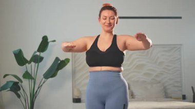 Fitness antrenmanı. Evde spor yapan bir kadın. Artı ev içinde spor egzersizi yapan beden bir kadın. Spor giyimli kız kilo vermek için ağırlık çalışması yapıyor. Spor ve zindelik