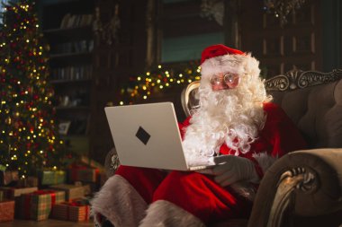Mutlu noeller. Bilgisayarlı Noel Baba, çocuklardan gelen mektupları okuyor ve internetten hediyeler alıyor. Noel arifesinde bilgisayarlı Noel Baba. Noel Baba 'nın posta hediyeleri. Kış Tatili Kutlamaları