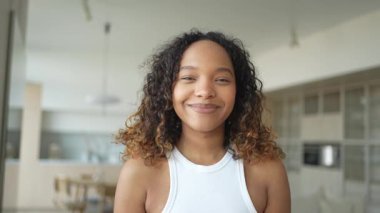 Afro saç stili gülümseyen güzel bir Afrikalı Amerikalı kız. Genç mutlu zenci kızın portresini yakından çek. Kıvırcık saçlı, gülen genç bir Afrikalı kadın. Özgürlük mutluluğu tasasız mutlu insanlar konsepti