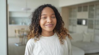 Afro saç stili gülümseyen güzel bir Afrikalı Amerikalı kız. Genç mutlu zenci kızın portresini yakından çek. Kıvırcık saçlı, gülen genç bir Afrikalı kadın. Özgürlük mutluluğu tasasız mutlu insanlar konsepti