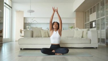 Yoga fitness antrenmanı. Sağlıklı Afrikalı kız evde yoga yapıyor. Pilates antrenmanı yapan bir kadın, yoga minderiyle spor yapıyor. Kız kilo vermek için antrenman yapıyor. Spor uygunluğu