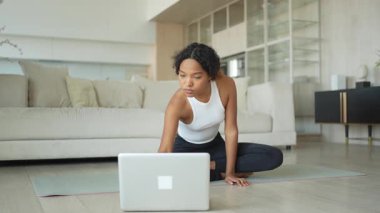 Yoga farkındalığı meditasyonu çevrimiçi. Afrikalı kadın evdeki bilgisayarında online derslerle yoga yapıyor. Lotus 'ta oturan kadın meditasyon yapıyor. Nefes egzersizi yapan bir kız. Evde yoga.