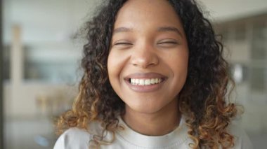 Afro saç stili gülümseyen güzel bir Afrikalı Amerikalı kız. Genç mutlu zenci kızın portresini yakından çek. Kıvırcık saçlı, gülen genç bir Afrikalı kadın. Özgürlük mutluluğu tasasız mutlu insanlar konsepti