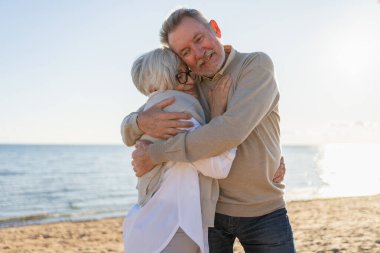 Yaşlı bir çift kumsalda yürüyüş yaparken kucaklaşıp eğleniyorlar. Yaşlı karı şefkatle kucaklaşıyor aşk tatlı bir bağın tadını çıkarıyor. Büyükannem ve büyükbabam birlikte. Aile anı aşkı