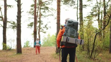 Turizm macerası yürüyüşü. Yaşlı çift erkek kadın ormanda gezintiden zevk alıyor. Mutlu yaşlı insan gezginleri doğa güzelliğinin aktif turizm yürüyüşünün tadını çıkarırlar.
