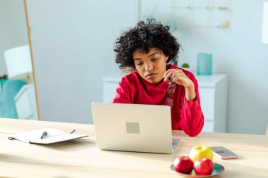 African american girl using laptop at home office looking at screen typing chatting reading writing email. Young woman having virtual meeting online chat video call conference. Work learning from home