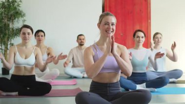 Yoga farkındalığı meditasyonu. Yoga sağlık farkındalığı meditasyonu için stüdyoda egzersiz yapan bir grup sporcu. Nilüfer çiçeğinde oturup yoga yapan erkek kadınlar meditasyon yapıyor.