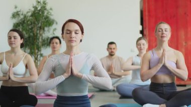 Yoga farkındalığı meditasyonu. Yoga sağlık farkındalığı meditasyonu için stüdyoda egzersiz yapan bir grup sporcu. Nilüfer çiçeğinde oturup yoga yapan erkek kadınlar meditasyon yapıyor.