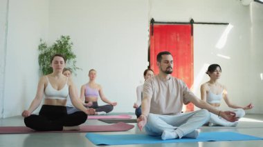 Yoga farkındalığı meditasyonu. Yoga sağlık farkındalığı meditasyonu için stüdyoda egzersiz yapan bir grup sporcu. Nilüfer çiçeğinde oturup yoga yapan erkek kadınlar meditasyon yapıyor.