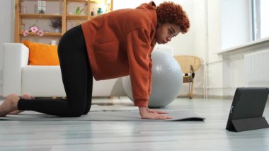 Fitness Workout training. Young healthy fit african girl doing sports exercise on yoga mat on floor at home. Athletic woman in sportswear have training workout for weight loss. Sport and fitness
