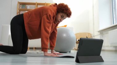 Fitness Workout training. Young healthy fit african girl doing sports exercise on yoga mat on floor at home. Athletic woman in sportswear have training workout for weight loss. Sport and fitness