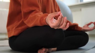 Yoga farkındalığı meditasyonu. Çene mudra hareketi yapan kadın elleri. Afrikalı kız evde yoga yapıyor. Lotus 'ta oturan kadın yoga minderinde poz veriyor içeride meditasyon yapıyor. Nefes egzersizi yapan kız.