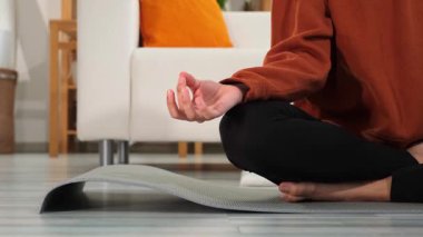 Yoga farkındalığı meditasyonu. Çene mudra hareketi yapan kadın elleri. Afrikalı kız evde yoga yapıyor. Lotus 'ta oturan kadın yoga minderinde poz veriyor içeride meditasyon yapıyor. Nefes egzersizi yapan kız.