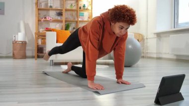 Fitness Workout training. Young healthy fit african girl doing sports exercise on yoga mat on floor at home. Athletic woman in sportswear have training workout for weight loss. Sport and fitness