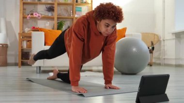 Fitness Workout training. Young healthy fit african girl doing sports exercise on yoga mat on floor at home. Athletic woman in sportswear have training workout for weight loss. Sport and fitness