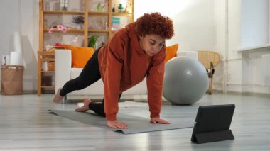 Fitness Workout training. Young healthy fit african girl doing sports exercise on yoga mat on floor at home. Athletic woman in sportswear have training workout for weight loss. Sport and fitness