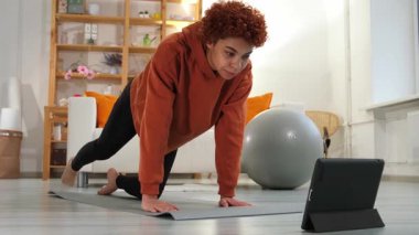 Fitness Workout training. Young healthy fit african girl doing sports exercise on yoga mat on floor at home. Athletic woman in sportswear have training workout for weight loss. Sport and fitness