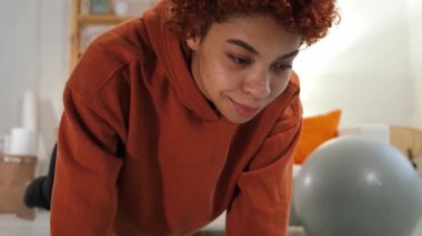 Fitness Workout training. Young healthy fit african girl doing sports exercise on yoga mat on floor at home. Athletic woman in sportswear have training workout for weight loss. Sport and fitness